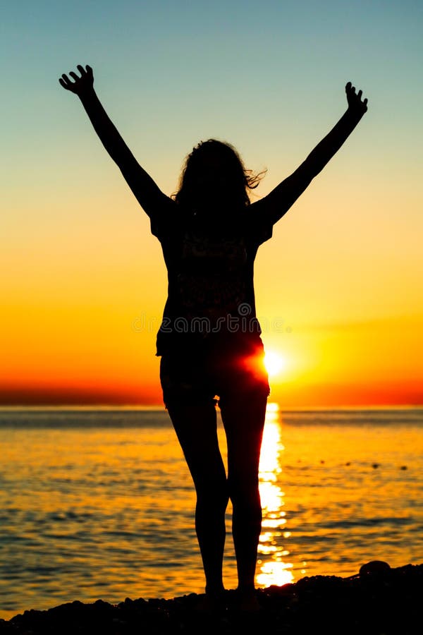 Silhouette of a girl at sunset on the sea stock images Silhouette of a girl at sunset on the sea stock images