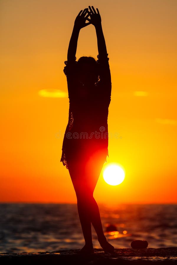 Silhouette of a girl at sunset on the sea stock images Silhouette of a girl at sunset on the sea stock images