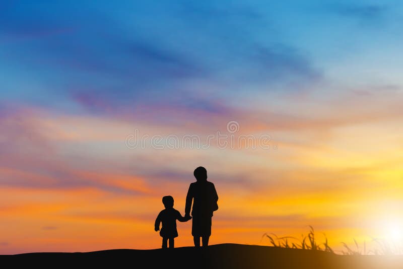 Silhouette of grandmother and grandchild looking sun down and walking on the beach evening sunset background, Happy family concept