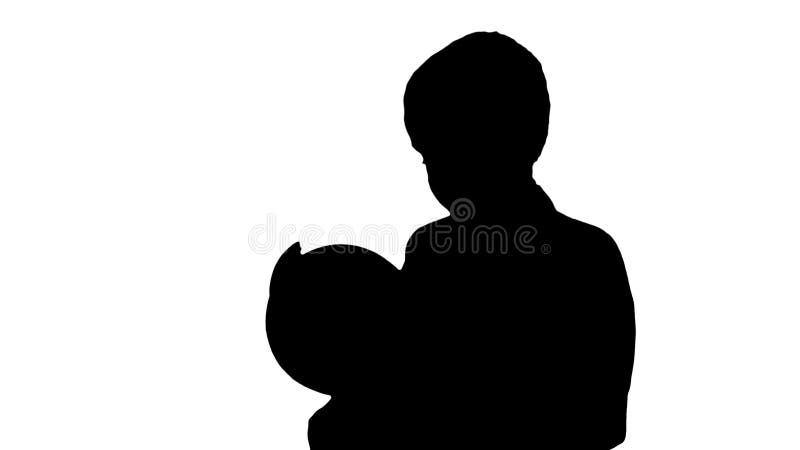 Silhouette happy schoolboy in a formal suit studying a globe.