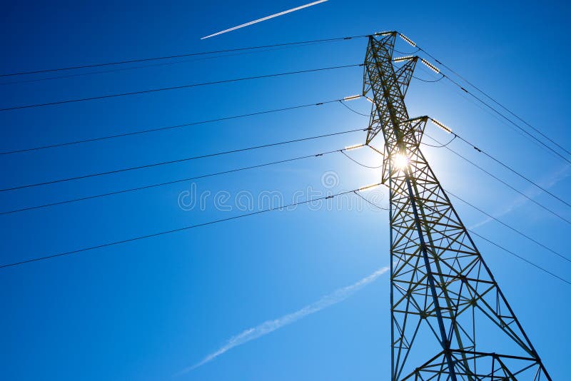 Silhouette of a high voltage pylon and blue sky