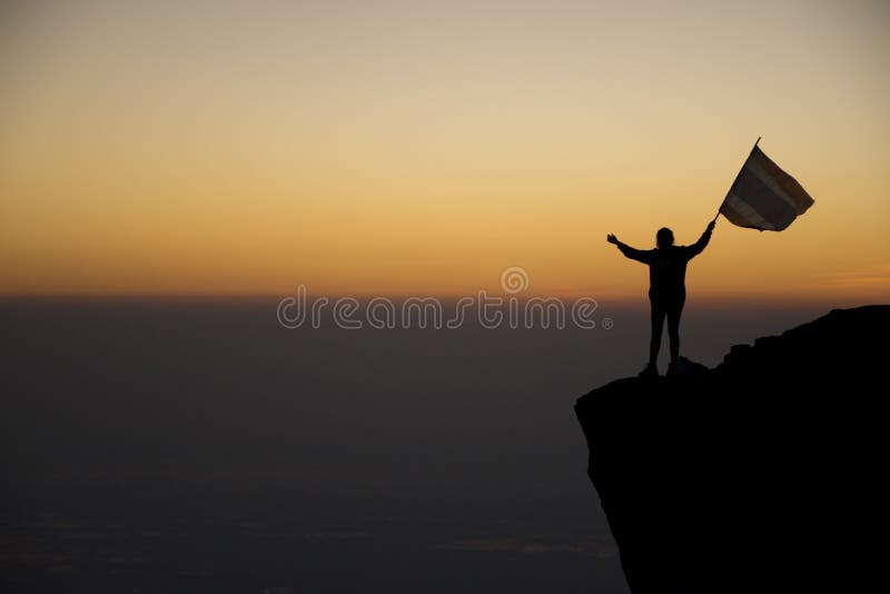Silhouette of Human and Flag on the Hill Background when Sunrise Stock