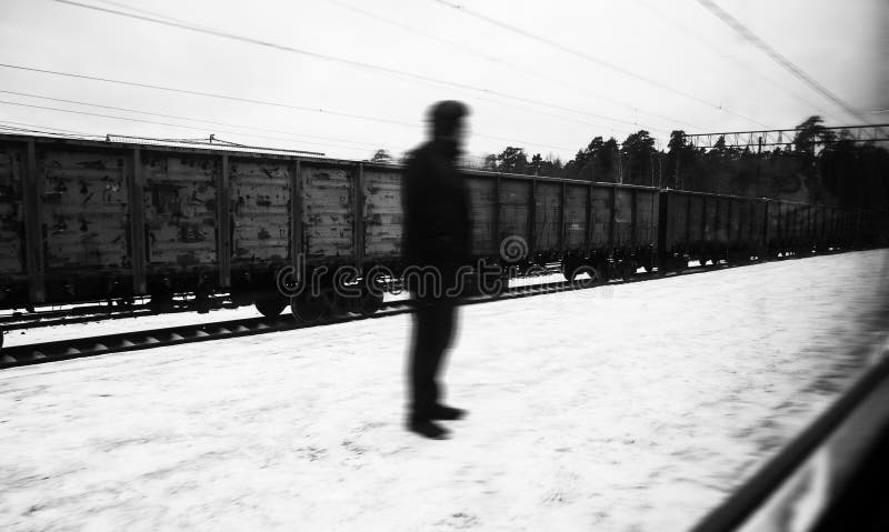 Silhouette inconnue de personne d'un homme mystique étrange, se tenant sur la rue, au fond des chariots de train de fret photographie stock Silhouette inconnue de personne d'un homme mystique étrange, se tenant sur la rue, au fond des chariots de train de fret photographie stock