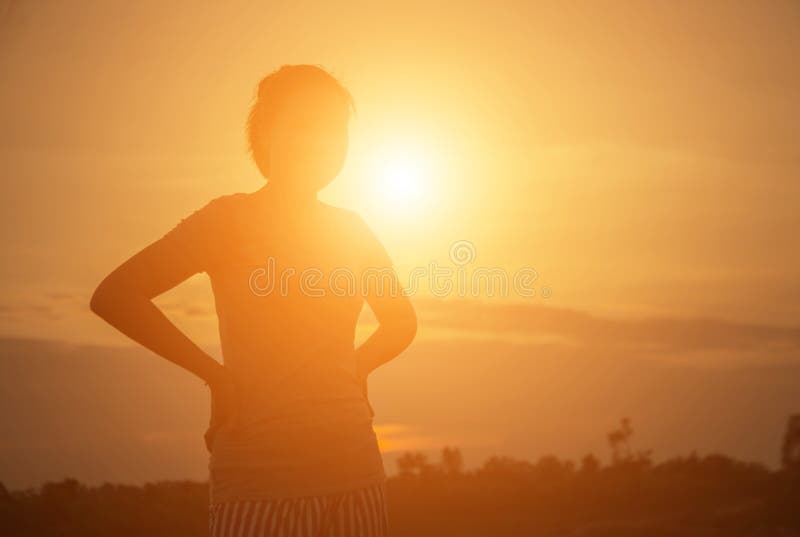 Silhouette jeune femme au coucher du soleil image stock Silhouette jeune femme au coucher du soleil image stock