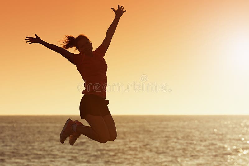 Silhouette of joyful woman jumping and having fun at the beach against the sunset royalty free stock image Silhouette of joyful woman jumping and having fun at the beach against the sunset royalty free stock image