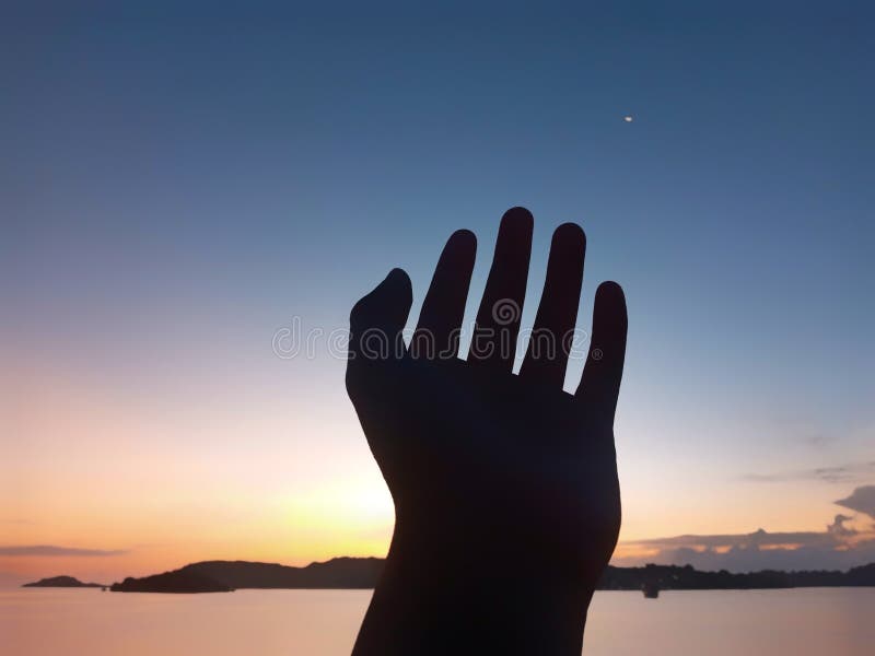 Silhouette of a Left Arm Reaching for the Sky during Sunrise Hours