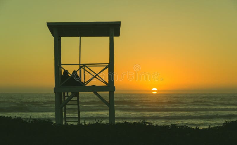 Couple lifeguard tower beach sunset