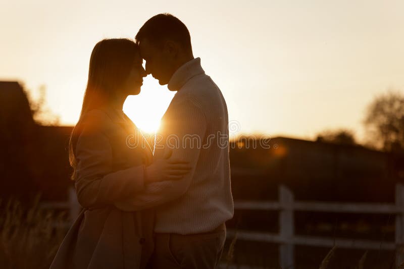 Silhouette Of Loving Couple Couple At Sunset Is Hugging And Touching