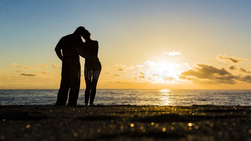 Silhouette of loving couple standing riverside and beautiful sunset background. royalty free stock photography Silhouette of loving couple standing riverside and beautiful sunset background. royalty free stock photography