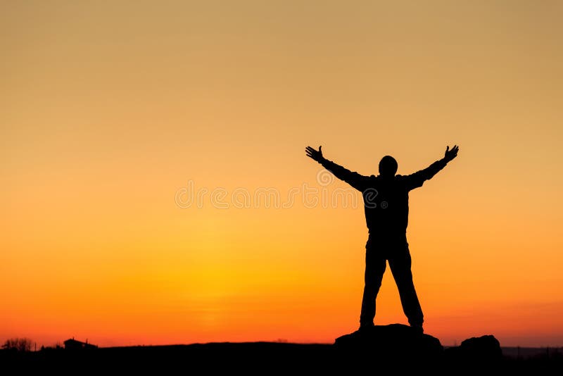 Silhouette of man with arms raised up and beautiful sky