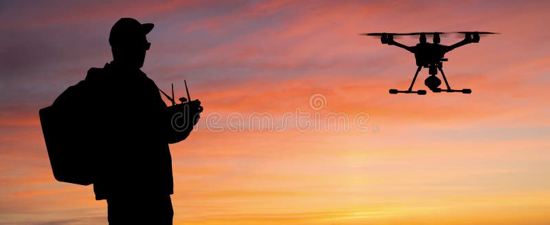 Silhouette of a man controls a drone stock photo