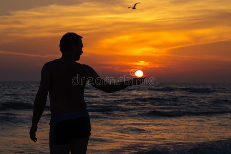 Hombres posesión el sol sobre el Playa durante atardecer.