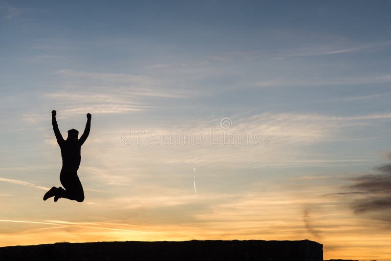 Silhouette of a man jumping high up in the air