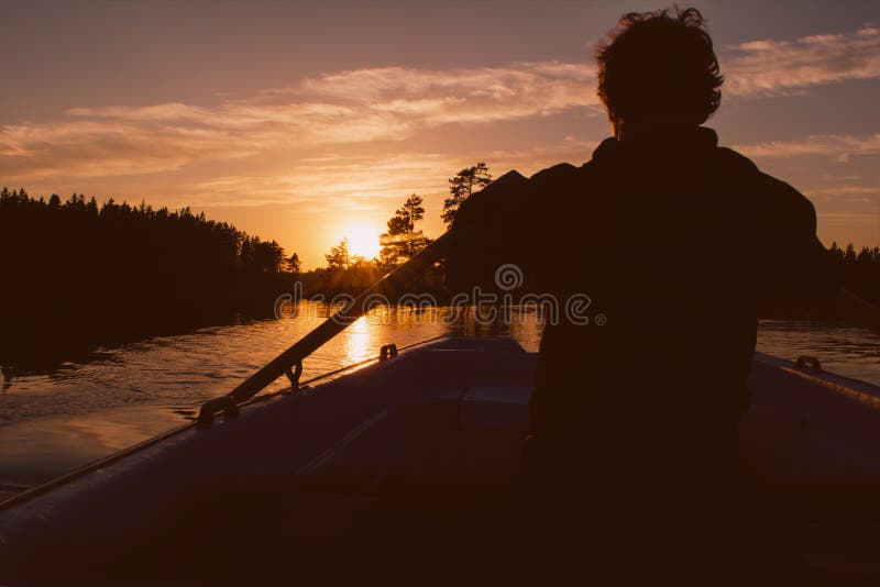 Silueta de hombre remo través de en hermoso verano atardecer.