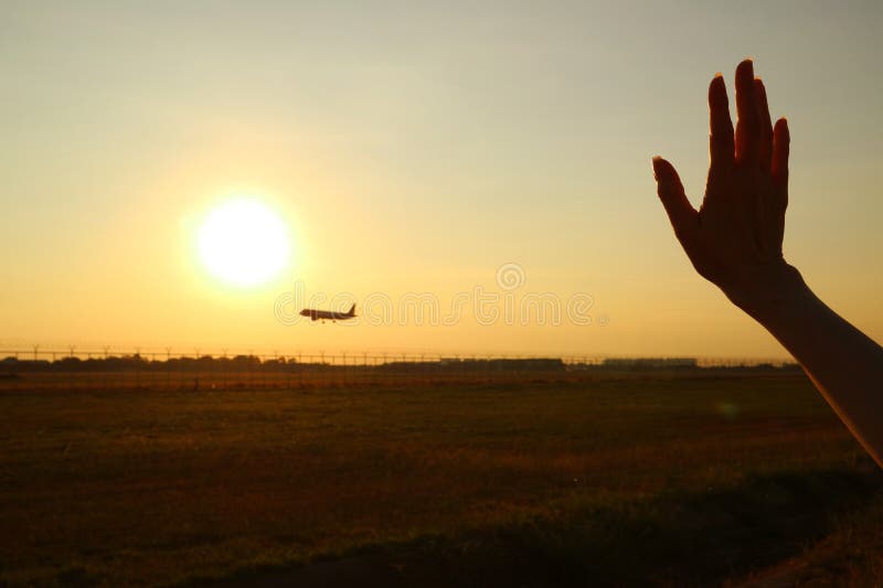 Silhouette med hand som viftade till flygplanet mot solnedgången royaltyfri fotografi Silhouette med hand som viftade till flygplanet mot solnedgången royaltyfri fotografi