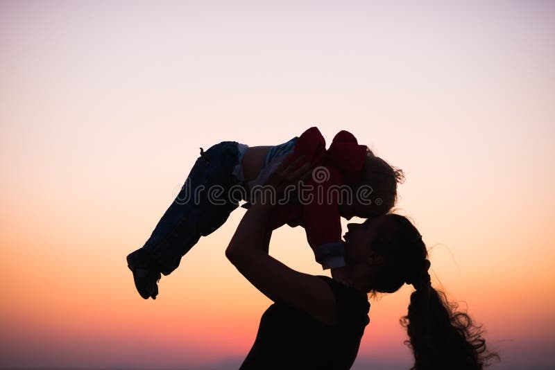 Silhouette of mother playing with baby in dusk stock photography Silhouette of mother playing with baby in dusk stock photography