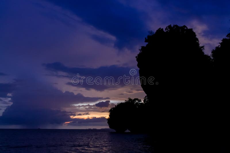 Silhouette of mountain cliff at violet sunset on sea beach resort in Thailand, Krabi, Railey and Tonsai stock photography Silhouette of mountain cliff at violet sunset on sea beach resort in Thailand, Krabi, Railey and Tonsai stock photography