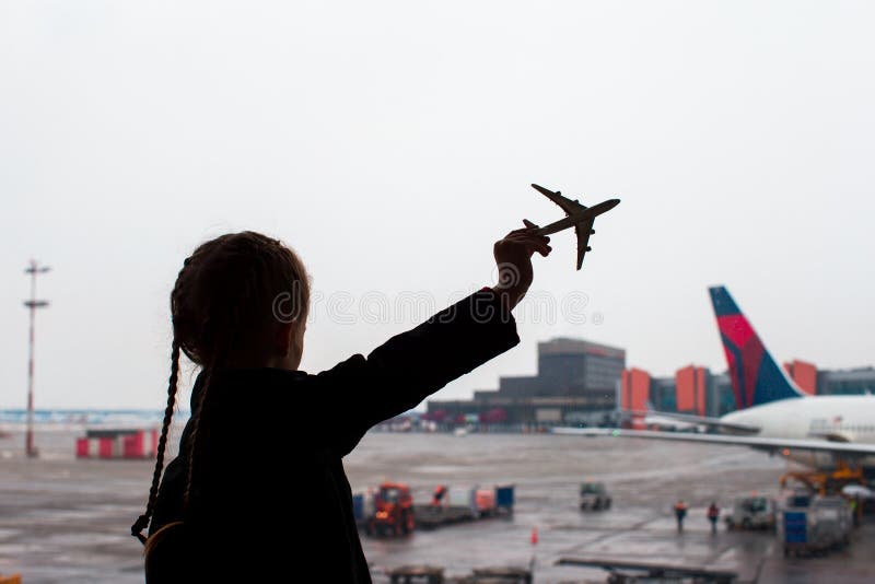 Silhouette noire d'un petit jouet de modèle d'avion sur l'aéroport dans des mains d'enfants images stock Silhouette noire d'un petit jouet de modèle d'avion sur l'aéroport dans des mains d'enfants images stock