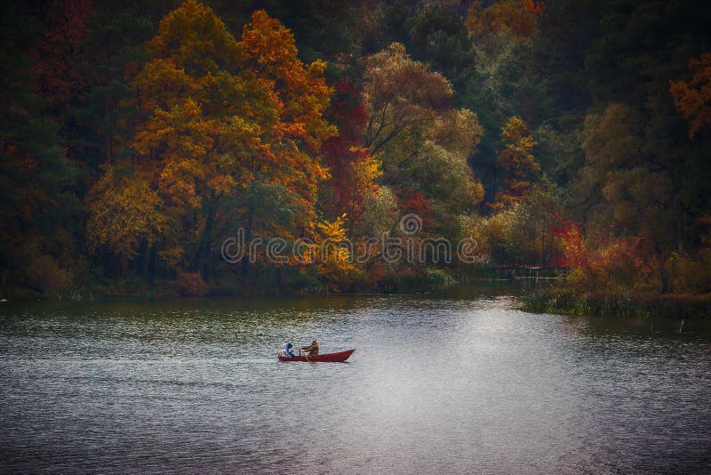 silhouette of a people on a boat in the autumn at sunset stock photos silhouette of a people on a boat in the autumn at sunset stock photos