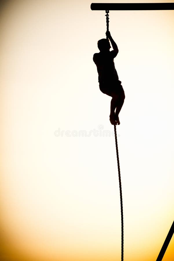 Silhouette of a person climbing a rope
