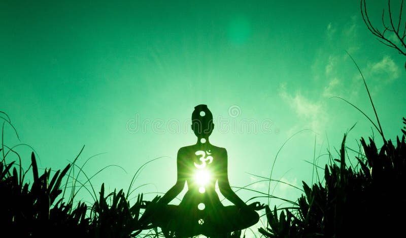 Silhouette of a person meditating with an open heart chakra under the sunlight