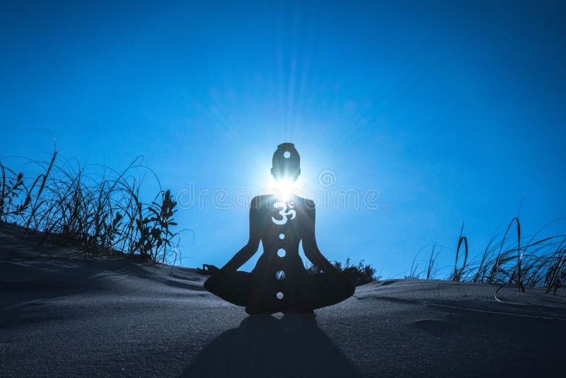 Silhouette of a person meditating with an open throat chakra under the sunlight