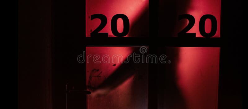 Silhouette of a person opening the door handle with date on window with a red strange backlight, destruction of the stereotype royalty free stock photography Silhouette of a person opening the door handle with date on window with a red strange backlight, destruction of the stereotype royalty free stock photography