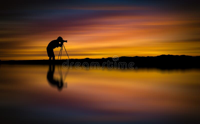 Silhouette Photographer take photo beautiful seascape at sunset