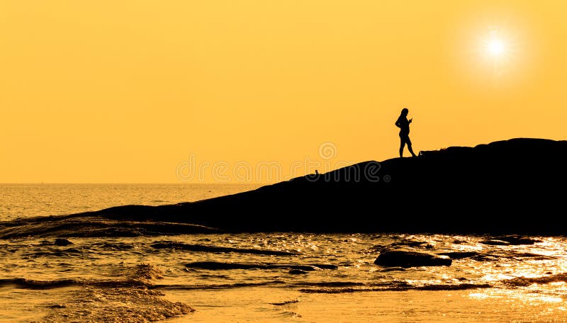 Silhouette pregnant women standing on rock in sea