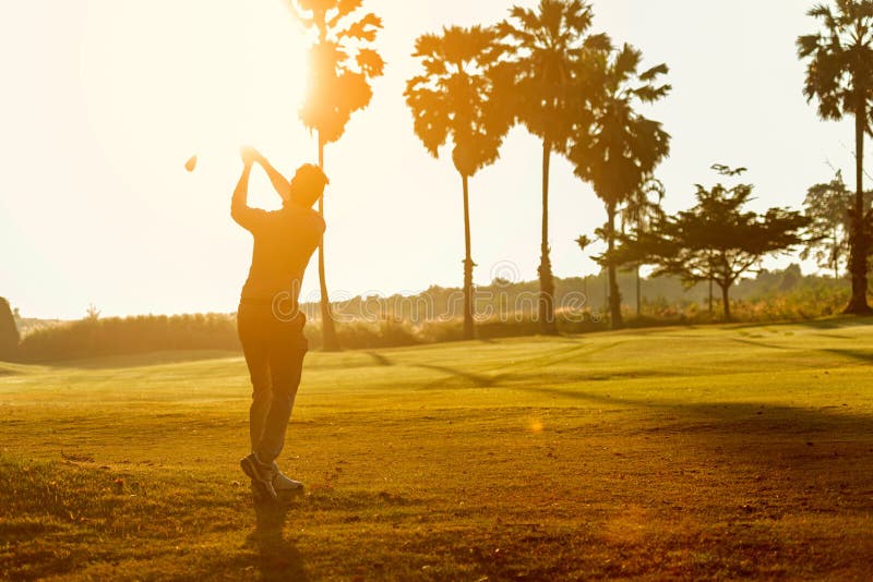 Silhouette Professional Golfer asian man swing and hitting golf ball practice at golf driving range and fairway in sunny morning d