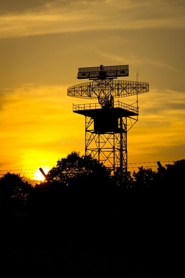 Silhouette radar tower plane and sunset