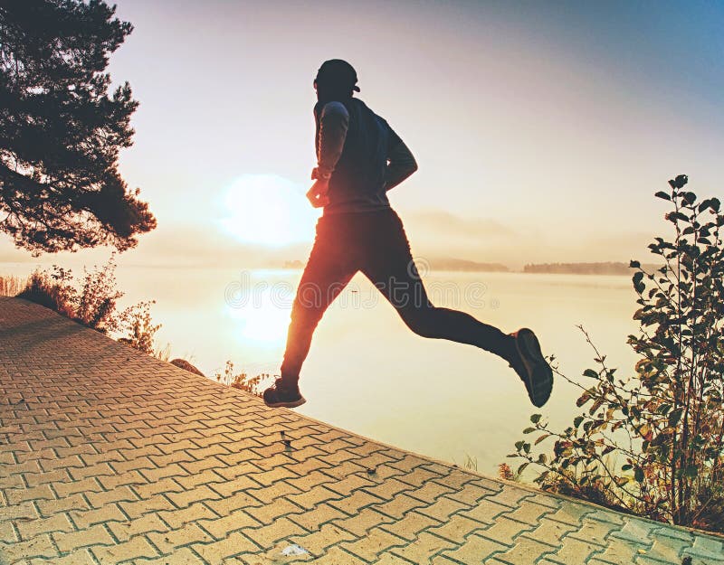 Silhouette of runner man along on the beach at sunset with sun royalty free stock photography Silhouette of runner man along on the beach at sunset with sun royalty free stock photography