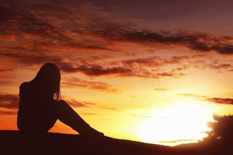 Silhouette sad expression woman sitting alone on top of the hill