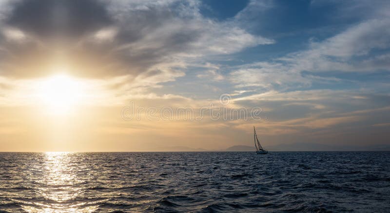 Silhouette Sail boat gliding in open sea at sunset. Tilted monohull in the evening