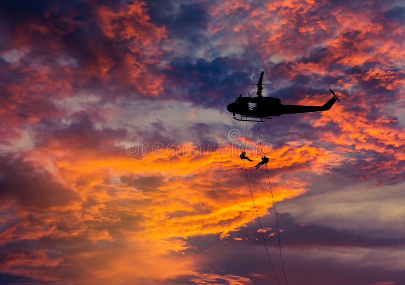 Silhouette soldiers in action rappelling climb down from helicopter with military mission counter terrorism on sunset stock images Silhouette soldiers in action rappelling climb down from helicopter with military mission counter terrorism on sunset stock images