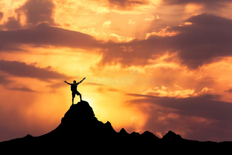 Silhouette of a standing happy man on the mountain peak
