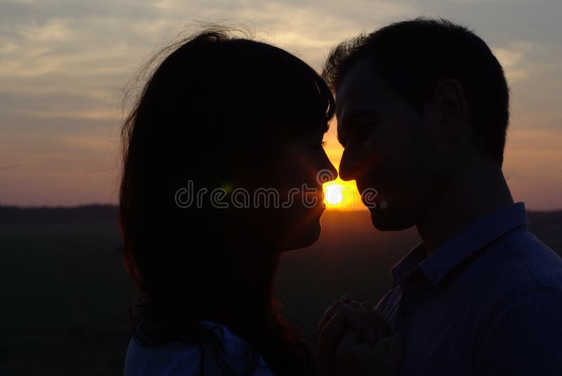 Silhouette sweethearts kissing at sunset royalty free stock photography Silhouette sweethearts kissing at sunset royalty free stock photography