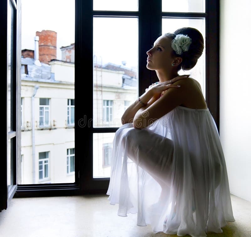 Silhouette of a thoughtful sad woman with hand near her forehead