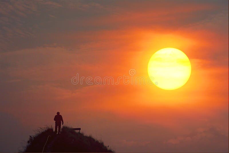 Silhouette traveler standing alone on the top of mountain looking the beauty sun dawn while the sky show multicolor and sun slowly
