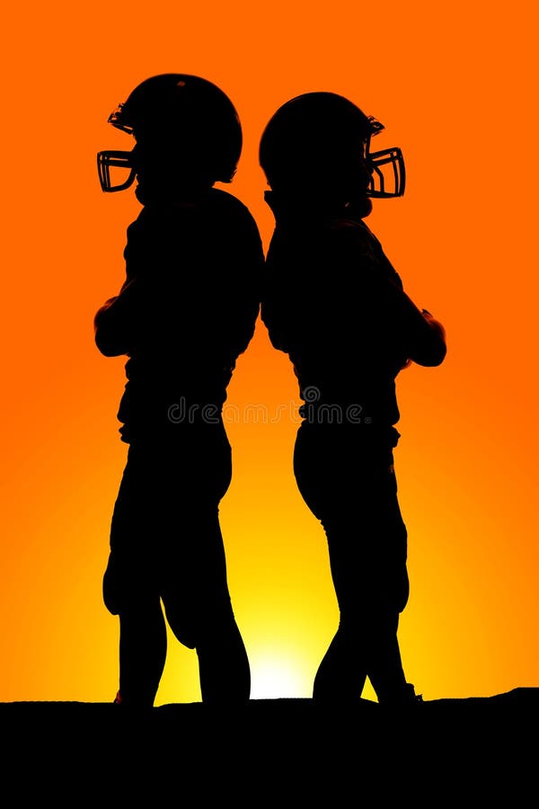 Silhouette of two football players back to back
