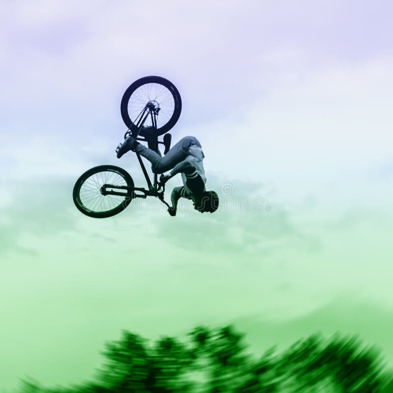 Silhouette of unidentified young man performs stunts on background of vivid sky. Extrem Sport and risk