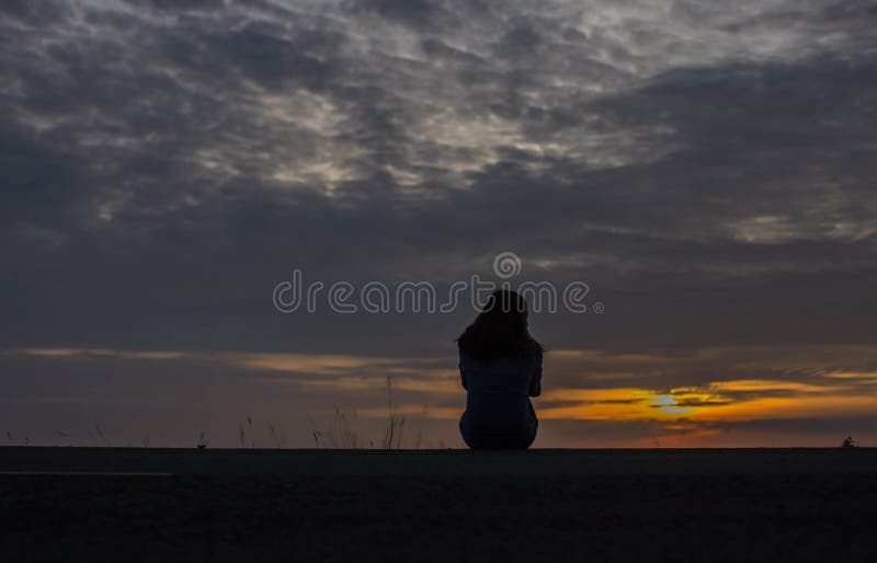 Silhouette von einsam depressiven und traurigen Frauen weinen und umarmen ihre Knie am Sonnenuntergang sitzen,Depressionskonzept lizenzfreies stockbild