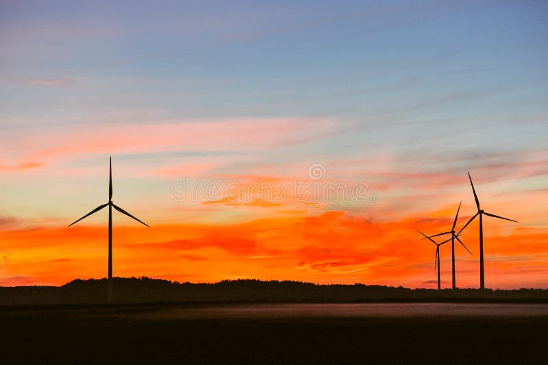 Silhouette of wind turbine on sunset