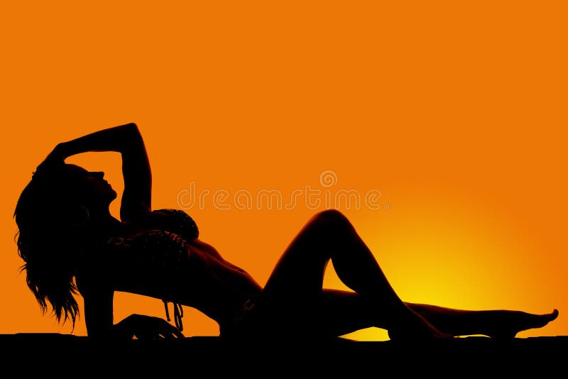 Silhouette of a woman in a bikini lay back knee up hand on head stock image Silhouette of a woman in a bikini lay back knee up hand on head stock image