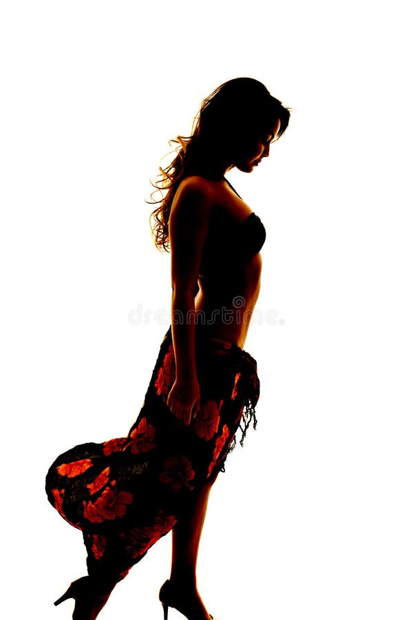 Silhouette of woman in bikini and sarong side look down