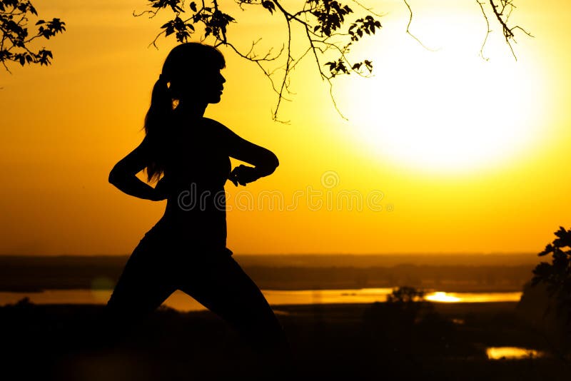 Silhouette of a woman doing physical exercises in nature at sunset, sports female on the field, concept of sports and recreation royalty free stock images Silhouette of a woman doing physical exercises in nature at sunset, sports female on the field, concept of sports and recreation royalty free stock images