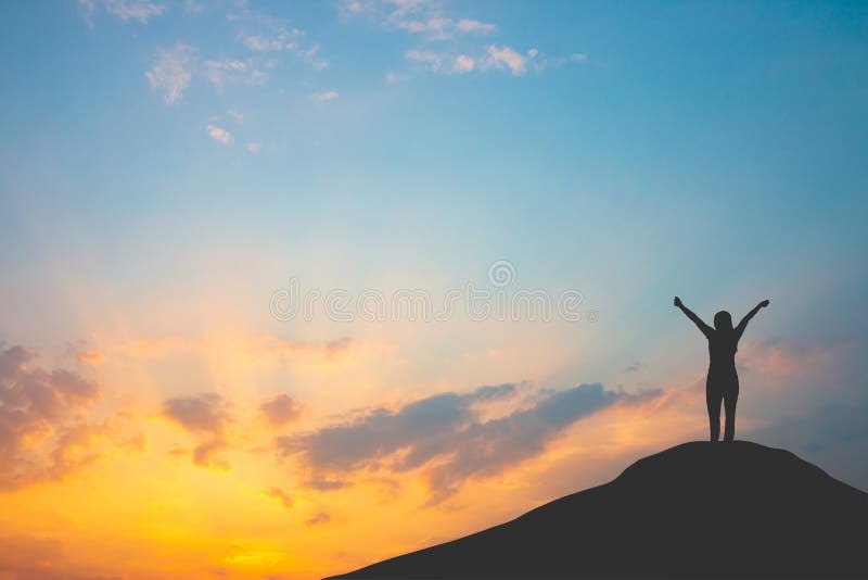 Silhouette of woman on mountain top over sky and sun light background,business, success