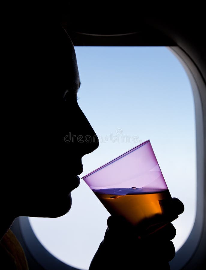 Silhouette of a Woman Passenger Beside Airplane Window