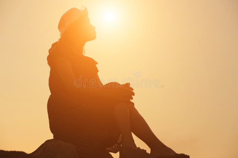 Silhouette of woman praying over beautiful sky background