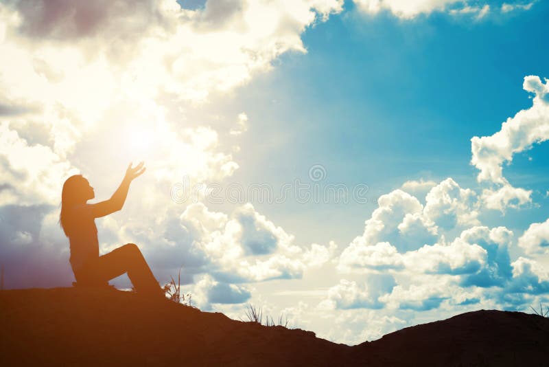 Silhouette of woman praying over beautiful sunrise